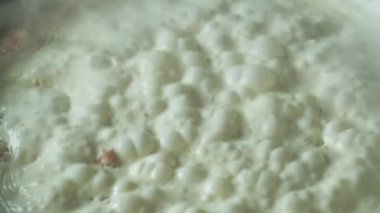 Şef bir tavada carbonara makarna için lezzetli kremalı bir sos pişirir. Lokantada lezzetli bir deniz ürünleri tabağı hazırlar.