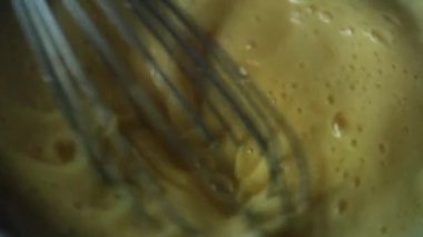 Yakın çekim şefi pasta için kremalı yumurtaları çırpıyor. 