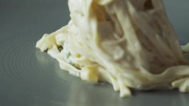 Şef, pişmiş Carbonara ezmesini yakın çekime koyar.