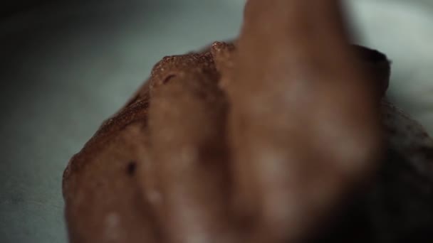 Крупный план шеф-повара, разбрасывающего шоколадный крем в металлическую миску, чтобы приготовить вкусный сладкий торт — стоковое видео