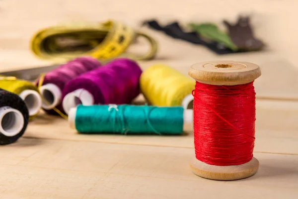 Wooden coil with red thread — Stock Photo, Image