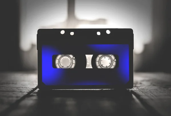 Musical cassette black and blue, on a wooden table Royalty Free Stock Images