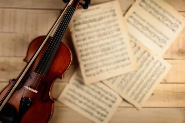 Violin sheets with notes lie on a wooden table — Stock Photo, Image