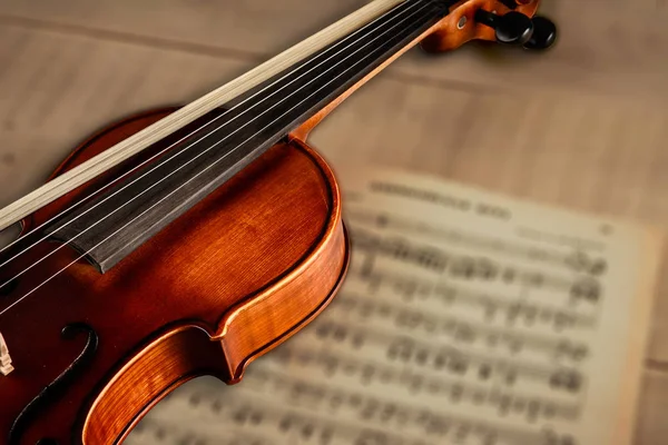 The violin lies on the table with notes — Stock Photo, Image