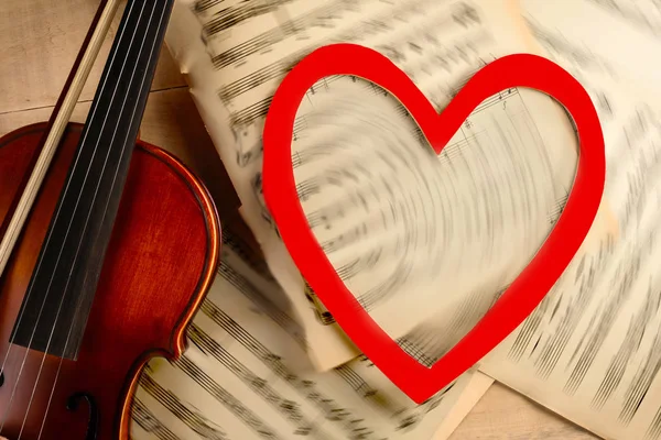 Violin notes and heart on a wooden table — Stock Photo, Image