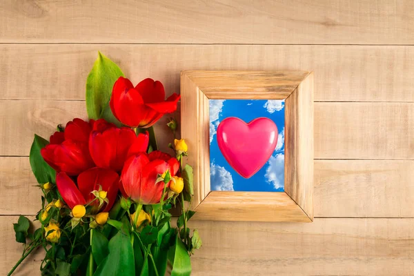 Bouquet of red tulips frame for photo with heart on sky backgrou — Stock Photo, Image