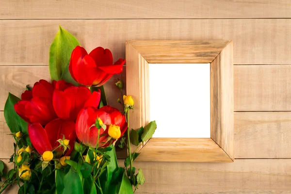 Tulipanes rojos rosas amarillas y marco para una foto con un blanco en blanco —  Fotos de Stock