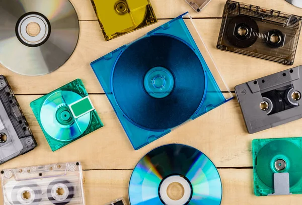 Cassette discs and floppy disks for music lie on a wooden table Stock Image