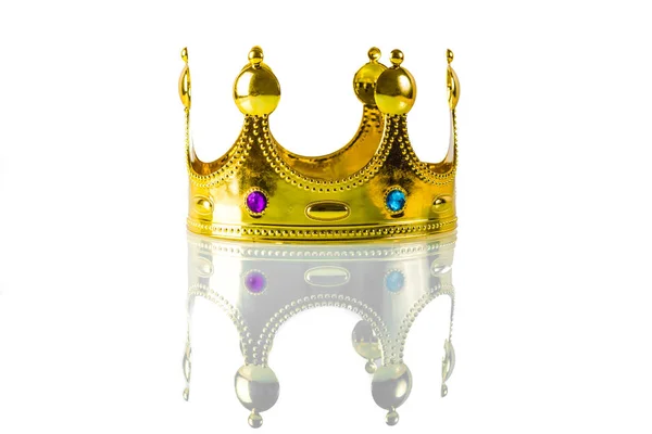 Golden crown with green and feolette lumps lies on a white backg Stock Image