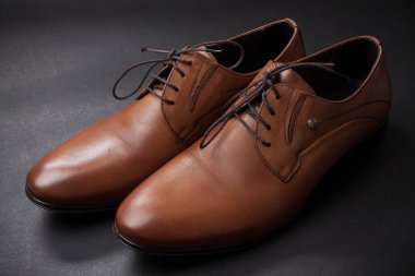 Düz siyah arka plan üzerinde kahverengi bir klasik erkek ayakkabı