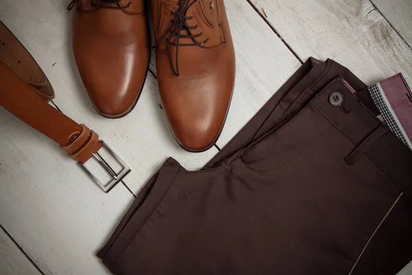 Nároky na oblečení. Kalhoty, boty a pásek na bílém vintage pozadí — Stock fotografie