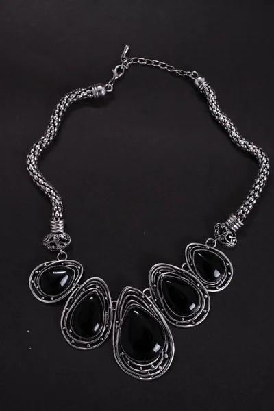 Красивое этническое металлическое ожерелье на черном — стоковое фото