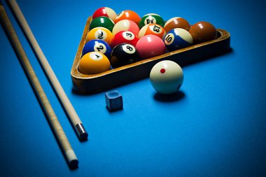 Image of billiard balls, cue and chalk on blue table clipart