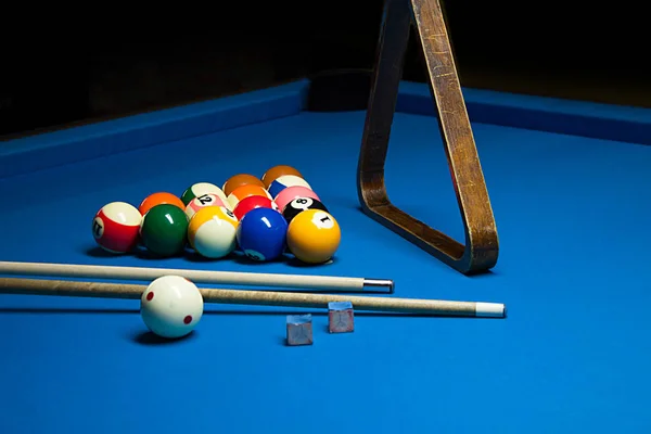 Изображение бильярдных шаров, мел и кия на синем столе — стоковое фото