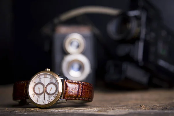 Primer plano tonificado tiro de relojes masculinos acostados en la mesa contra photog —  Fotos de Stock