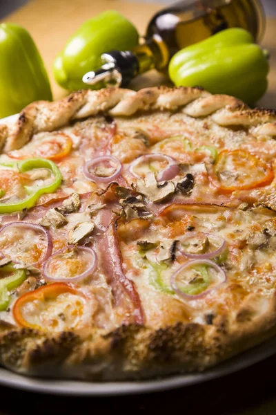 Deliciosa pizza brilhante em um fundo de madeira escura, pizza italiana Fotos De Bancos De Imagens