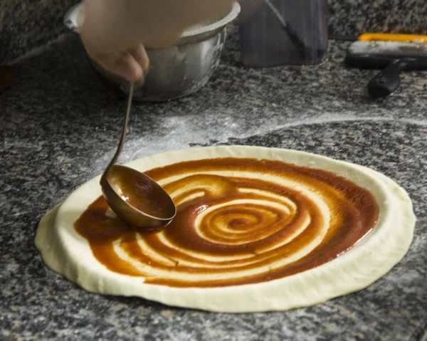Свежая оригинальная итальянская сырая пицца, крупный план мужских рук в действии, Pizza Art. Процесс приготовления пиццы Лицензионные Стоковые Фото