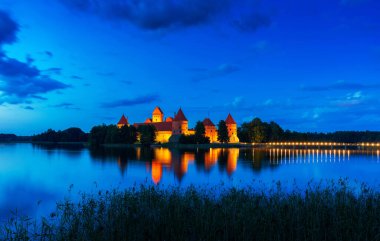 Eski ortaçağ kalesi Trakai, Litvanya. Litvanya Kültür Merkezi ve Tarih Müzesi. Sıcak bir yaz akşamında güzel aydınlatılmış bir şatonun kıyıdan görünüşü.