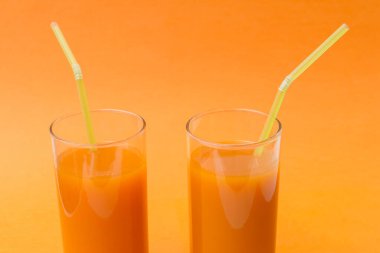 İki bardak taze sıkılmış portakal havucu suyu.