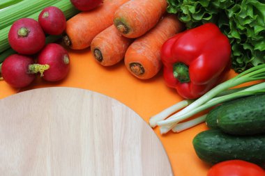 Taze sebzeler kesim tahtasının etrafına dizilir.
