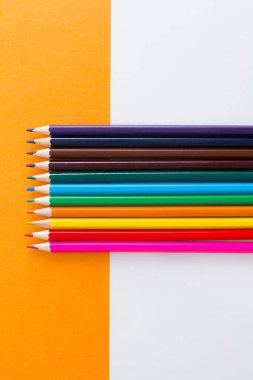 Turuncu arka planda renkli kalemler