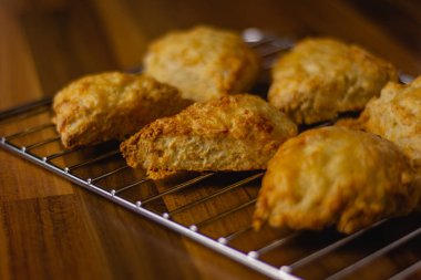 Metal tel soğutma rafında duran peynirli çörekler.