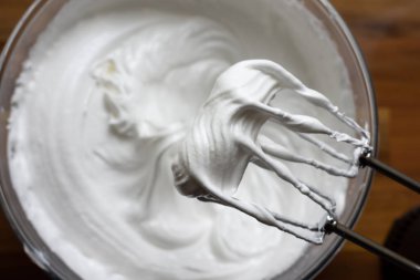 Elektrikli mikser çırpıcıları yumuşak bir karışım üzerinde ve çırpıcıları hala kremayla kaplı.