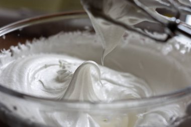 Yumuşak meringue zirveleri, klasik sert zirveleri oluşturan kremayla taze çırpılmış. Karıştırıcı kremanın mixlemesini bitirdiğini gösteriyor..