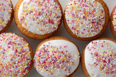 Çok renkli şeker parçacıklarıyla kaplı bir sürü buzlu kek.