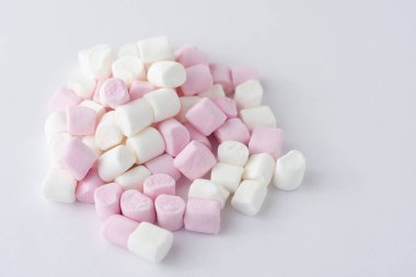 Beyaz arka planda pembe ve beyaz şekerlemeler.