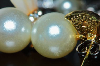 Arka plan için makrodaki kadının güzel inci küpeleri.