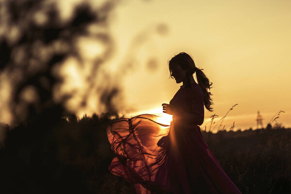Beautiful girl in transparent dress chiffon tantset at sunset