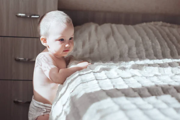 Baby stand near bed — Stock Photo, Image