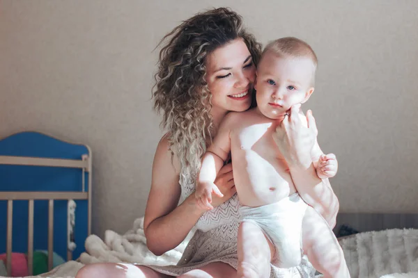 Madre y niño sentado en la cama y abrazo — Foto de Stock