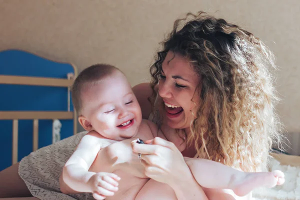 Moeder en baby lachen op bed — Stockfoto