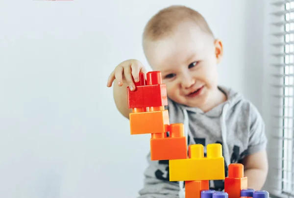 아이 장난감 벽돌을 만들기입니다. 장난감 타워입니다. 행복 한 아기 소년입니다. 장난감에 초점. 아기 산만된 — 스톡 사진