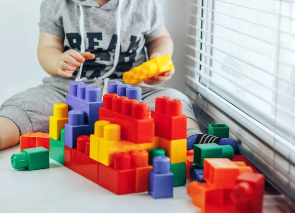 아기 놀이 constructorlittle 아기 창 근처 다채로운 플라스틱 블록 생성자의 많은 재생 — 스톡 사진