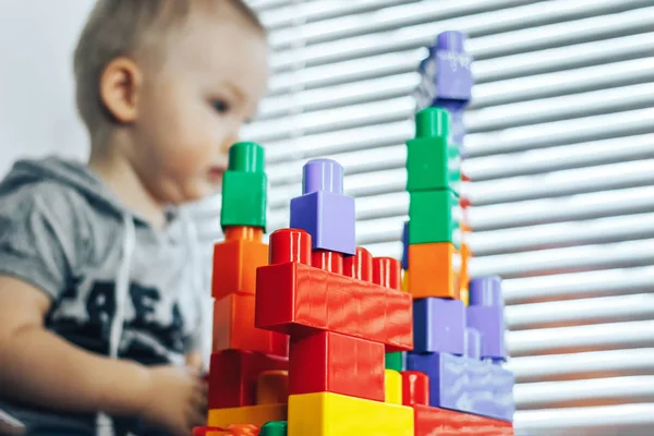 Хлопчик грає з блоками від іграшкового конструктора. Дитина не орієнтована, фокус на іграшках . — стокове фото
