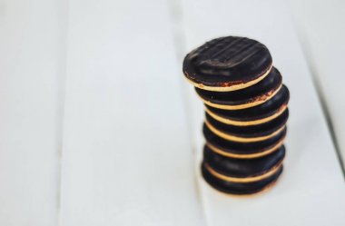 Beyaz ahşap zemin tanımlama bilgisi yığını. Yuvarlak bisküvi çikolata sır içinde. Birbirimizi üzerinde duruyor