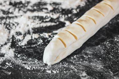 hamur meyilli bir somun için kesti. Nağmeleme kesme. Haşhaş tohumu salyangoz yapma. Tatlı rulo çörek.