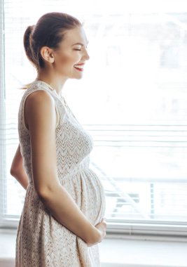 mutlu hamile kız evde beyaz elbiseli