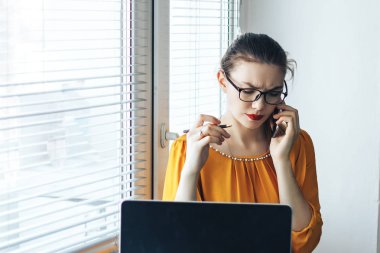 Cep telefonu üzerinde konuşurken ve taşınabilir net-kitap, kadın Sekreter patronu o dizüstü bilgisayar ağda yeni proje hakkında okumak ne söylemek için aradım ilgili gerekli bilgileri okuma kendine güvenen kadın