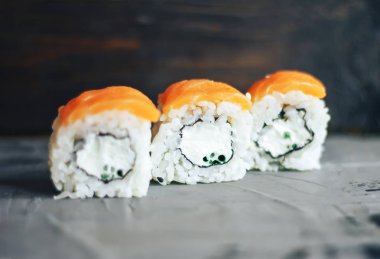 Somon suşi rulo ile kırmızı balık üzerinde ahşap arka plan