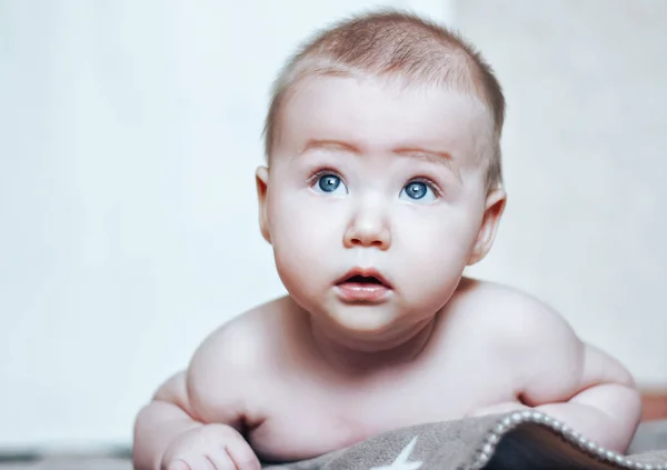 Ritratto di dolce bambino. Bambino di due mesi sdraiato su una coperta marrone . — Foto Stock