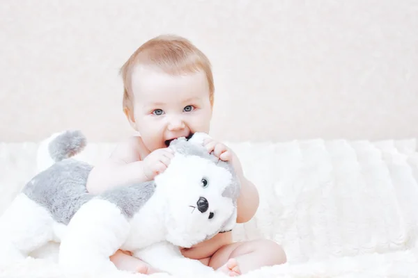 Şirin Bebek kız yatak odasında yatak yumuşak oyuncak ile oynarken — Stok fotoğraf