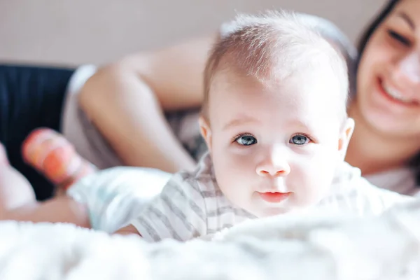 Küçük bebek anne odaklanmamış kameraya, seyir — Stok fotoğraf