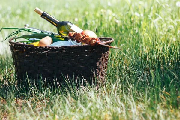 Корзина для пикника с едой на зеленой солнечной лужайке . — стоковое фото