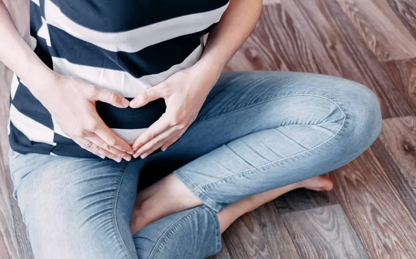 妊娠中の女性が自宅の床に座って — ストック写真