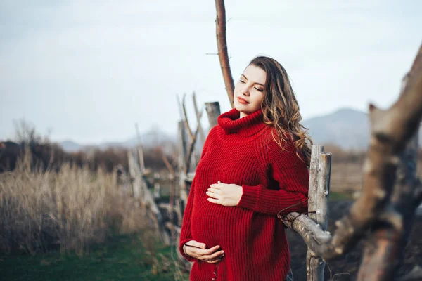 Donna incinta in maglione rosso all'aperto in occhiali rotondi — Foto Stock