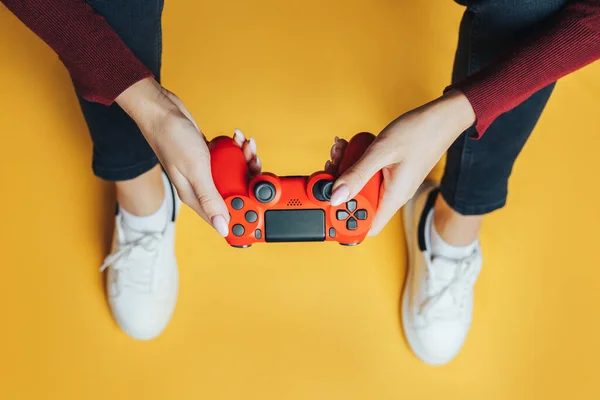 Young woman playing with gamepad on yellow. — Stock Photo, Image